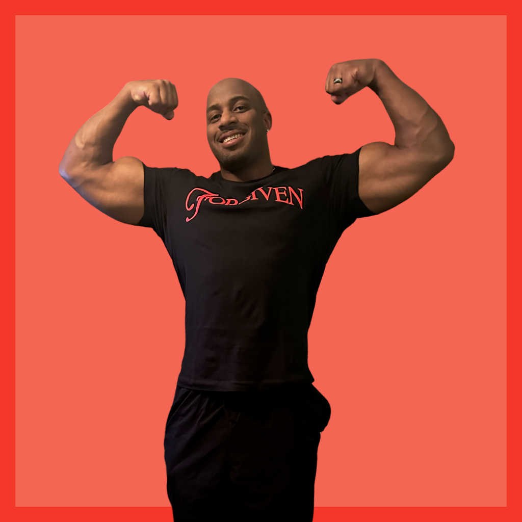 Man flexing muscles wearing a black 'Forgiven' t-shirt on a red background